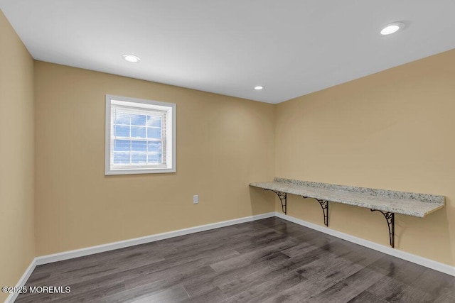 spare room featuring baseboards, dark wood finished floors, and recessed lighting