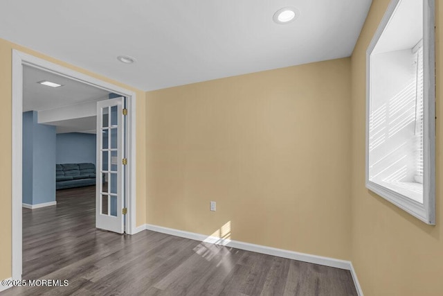 spare room with dark wood-style flooring and baseboards