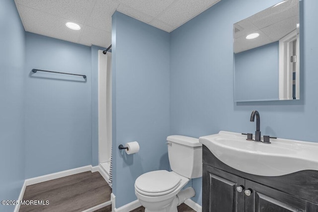 full bathroom featuring a shower, baseboards, toilet, and wood finished floors