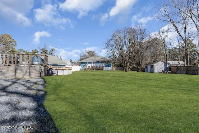 view of yard with a fenced in pool, an outbuilding, fence, and a storage unit