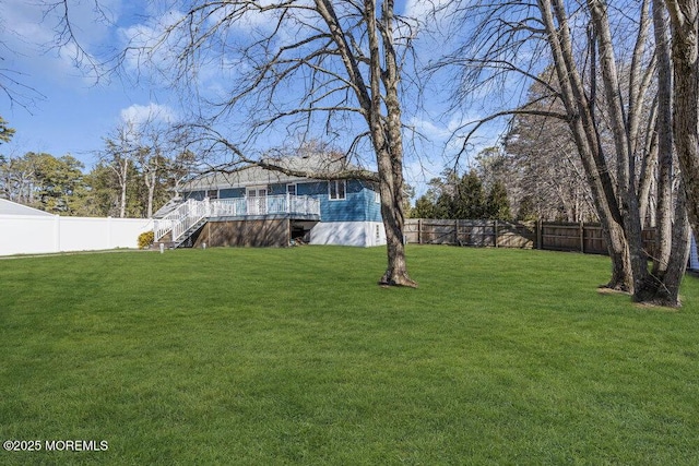 view of yard featuring stairway, a wooden deck, and a fenced backyard