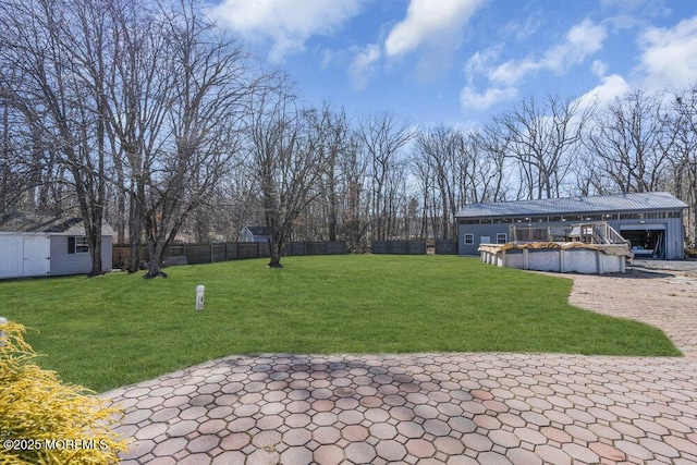 view of yard with a fenced in pool, a patio, a storage unit, fence, and an outdoor structure