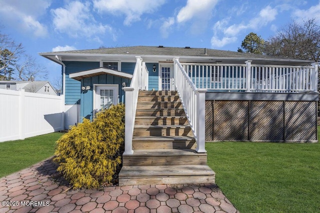 exterior space with a lawn, stairway, fence, a deck, and board and batten siding