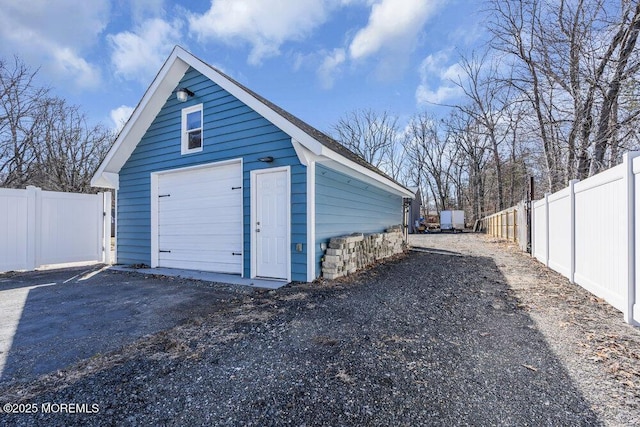 detached garage with driveway and fence