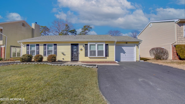 ranch-style house featuring a garage, driveway, and a front lawn