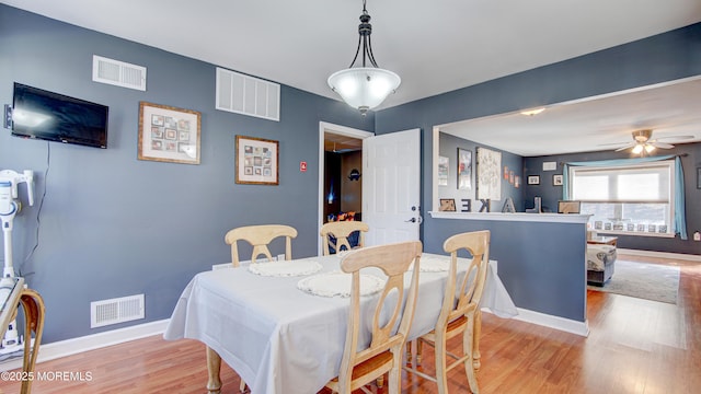 dining space with light wood-style floors, baseboards, and visible vents