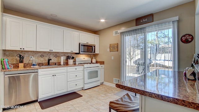 kitchen with visible vents, backsplash, appliances with stainless steel finishes, white cabinetry, and a sink