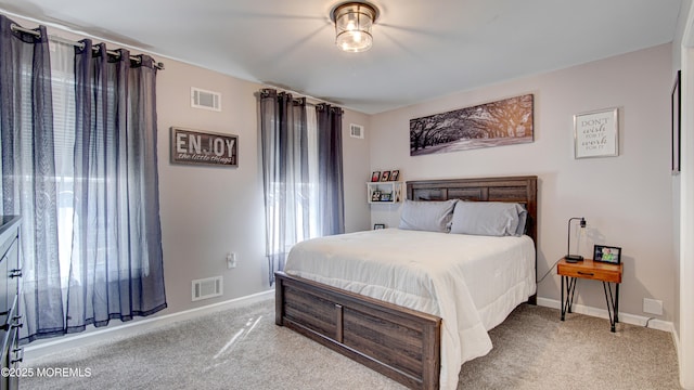 bedroom with light carpet, visible vents, and baseboards