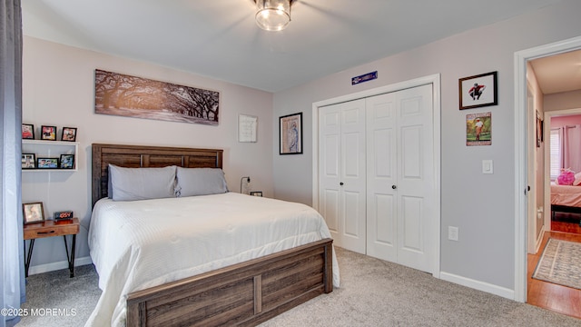 bedroom featuring a closet, light colored carpet, and baseboards