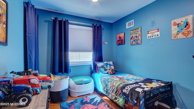 bedroom with visible vents and wood finished floors