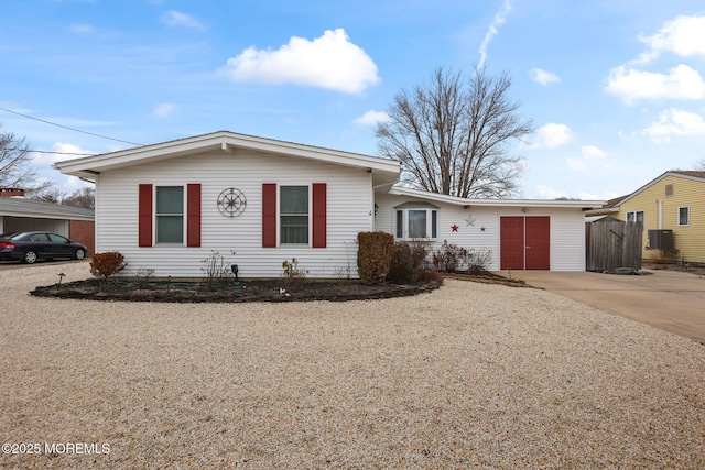 ranch-style house featuring driveway and fence