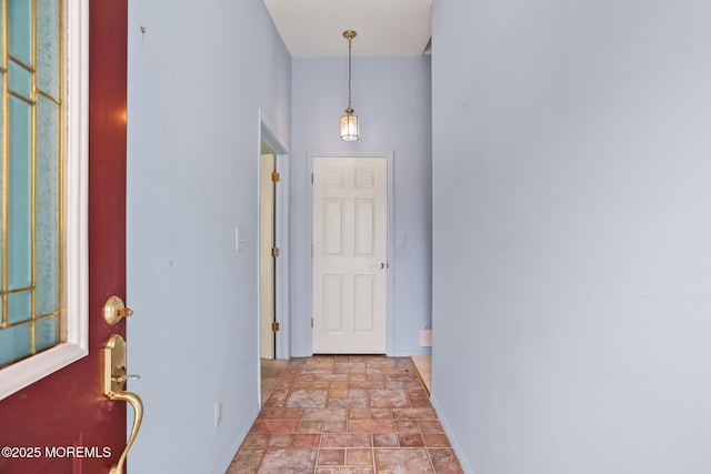 entrance foyer featuring stone finish flooring and baseboards