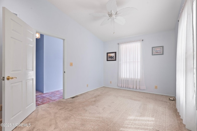 unfurnished room with carpet, vaulted ceiling, visible vents, and ceiling fan