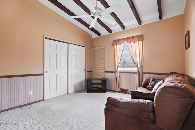 living room featuring lofted ceiling with beams, visible vents, carpet flooring, and wainscoting