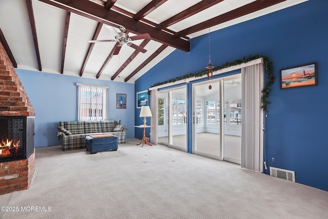 sitting room featuring visible vents, lofted ceiling with beams, ceiling fan, carpet flooring, and a brick fireplace