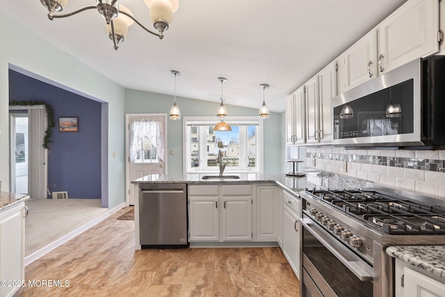 kitchen with lofted ceiling, white cabinetry, stainless steel appliances, and a sink