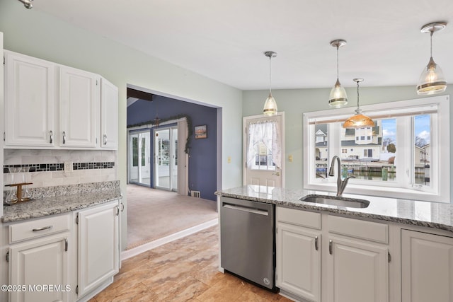 kitchen featuring a sink, white cabinetry, light stone counters, and stainless steel dishwasher