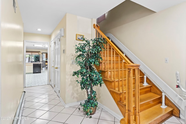 staircase featuring baseboards and tile patterned flooring