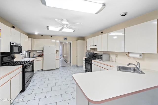 kitchen with black appliances, a sink, under cabinet range hood, light countertops, and light tile patterned floors