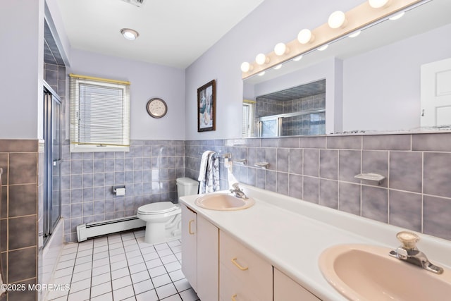 full bath with tile patterned flooring, a shower with shower door, baseboard heating, and a sink