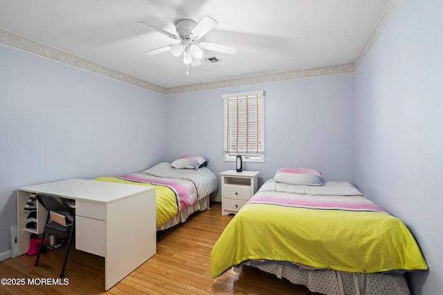 bedroom featuring visible vents, light wood-style floors, and a ceiling fan