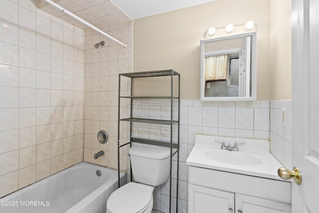 bathroom featuring vanity, shower / bathing tub combination, wainscoting, tile walls, and toilet