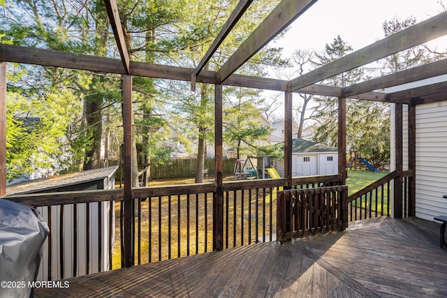 wooden deck with grilling area and a playground