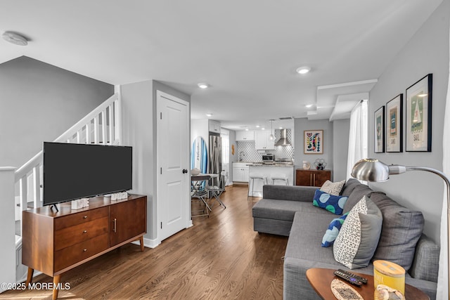 living area featuring stairs, dark wood-style flooring, and recessed lighting