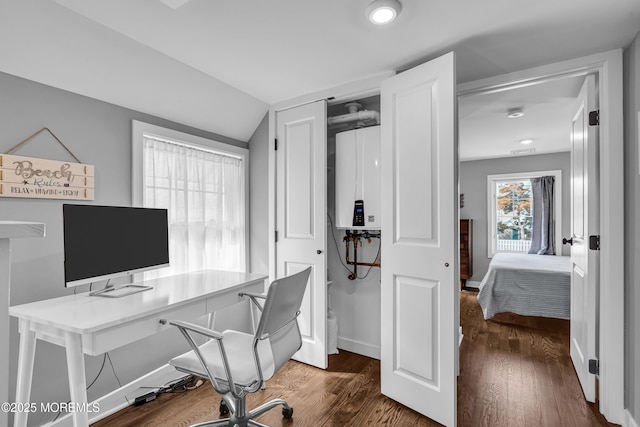 office space with dark wood-style floors, tankless water heater, vaulted ceiling, and baseboards