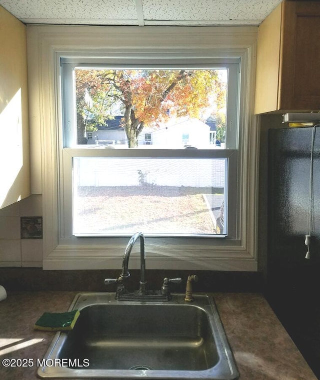 kitchen featuring dark countertops and a sink