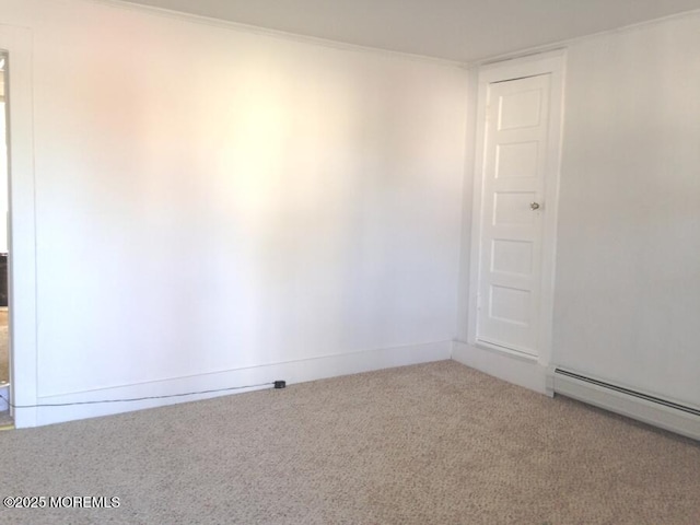 carpeted empty room featuring baseboards, baseboard heating, and crown molding