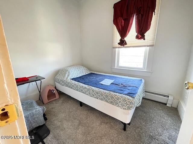 carpeted bedroom with a baseboard heating unit