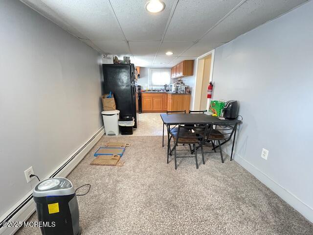 dining space featuring light carpet, baseboard heating, and baseboards