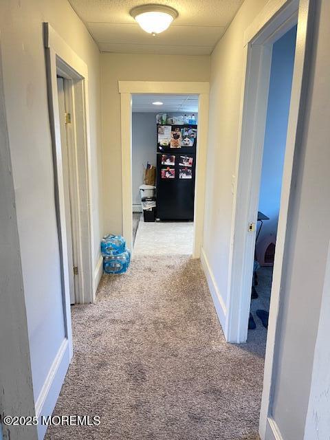 hallway featuring carpet floors and baseboards