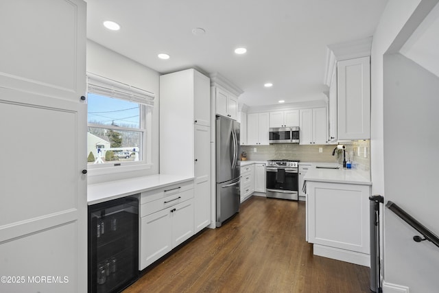 kitchen featuring light countertops, appliances with stainless steel finishes, wine cooler, and white cabinets