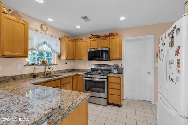 kitchen with visible vents, light stone counters, stainless steel appliances, a sink, and recessed lighting