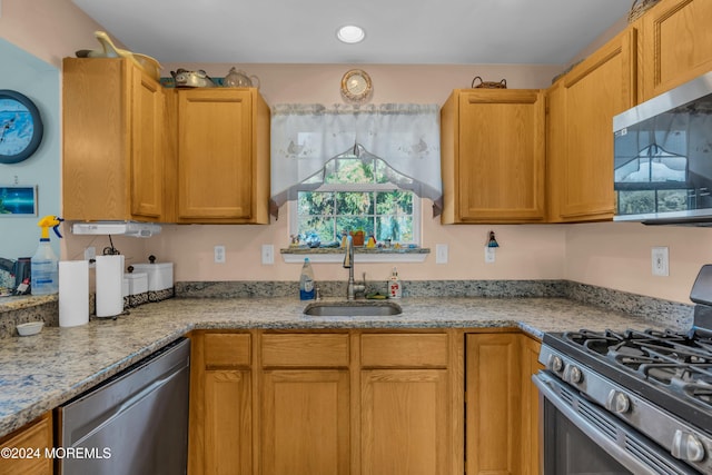 kitchen featuring appliances with stainless steel finishes, recessed lighting, a sink, and light stone countertops