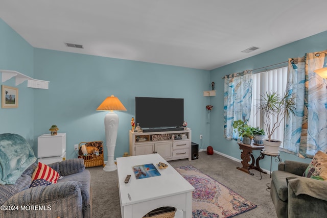 living area featuring baseboards, visible vents, and light colored carpet