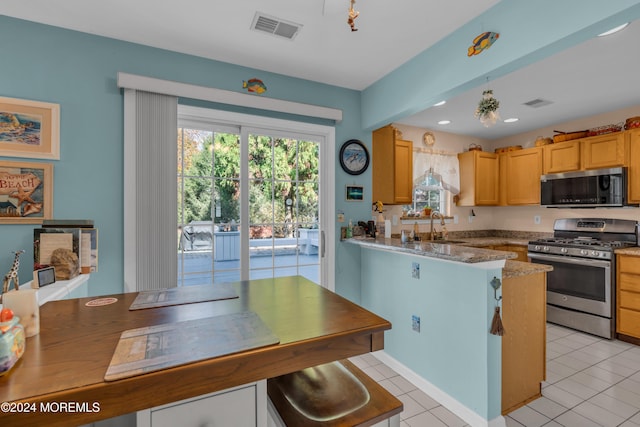 kitchen with light tile patterned floors, visible vents, appliances with stainless steel finishes, a sink, and light stone countertops