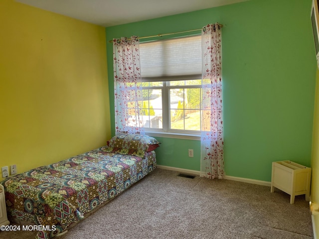 carpeted bedroom with visible vents and baseboards