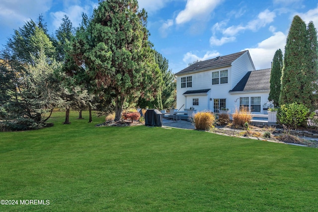 back of house featuring a wooden deck and a yard