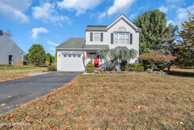 traditional-style home featuring driveway, a garage, and a front yard