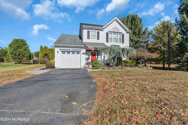 traditional-style home with a garage, driveway, and a front lawn