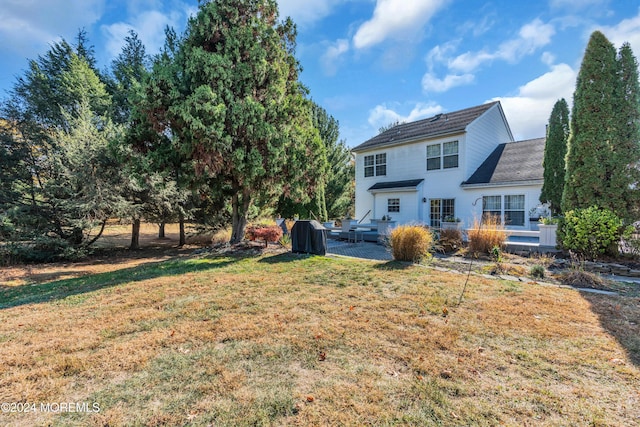 back of house featuring a yard and a wooden deck