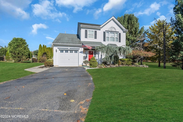 traditional home featuring a garage, driveway, and a front yard