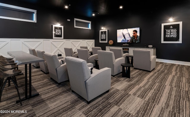 home theater room featuring dark colored carpet and a decorative wall