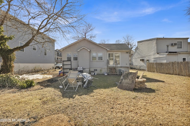 rear view of property featuring entry steps and fence