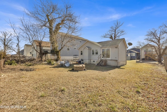 back of property featuring entry steps and a lawn