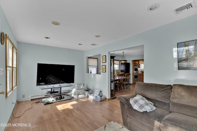 living area with wood finished floors and visible vents