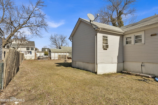 view of property exterior with a yard, cooling unit, and fence